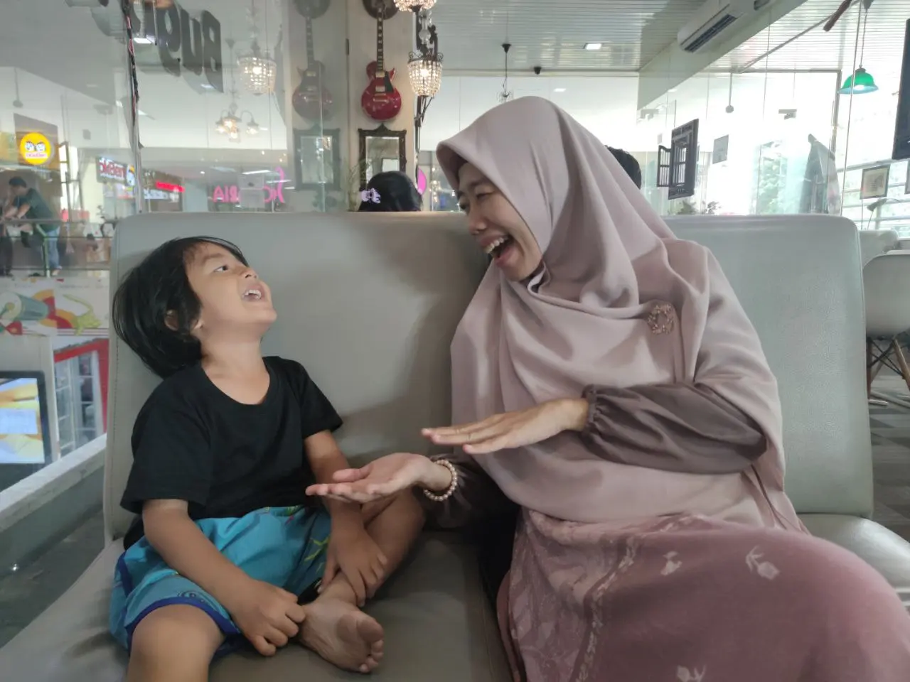 Ibu mendengarkan anak sambil tertawa bersama