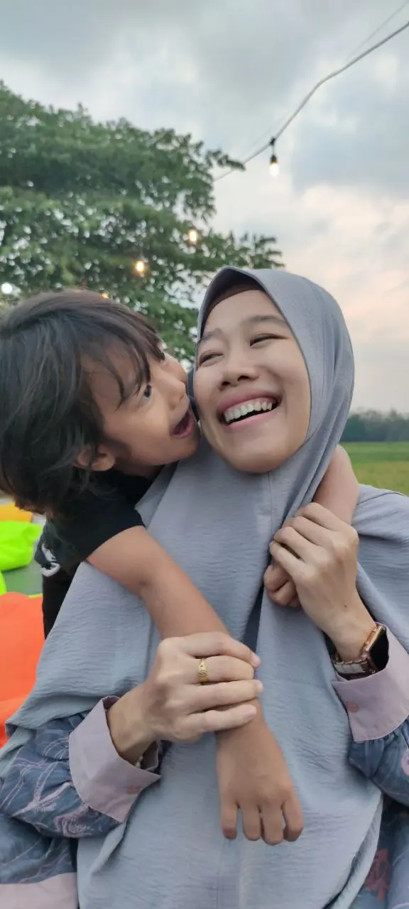 Ibu dan anak perempuan saling berpelukan dan tertawa
