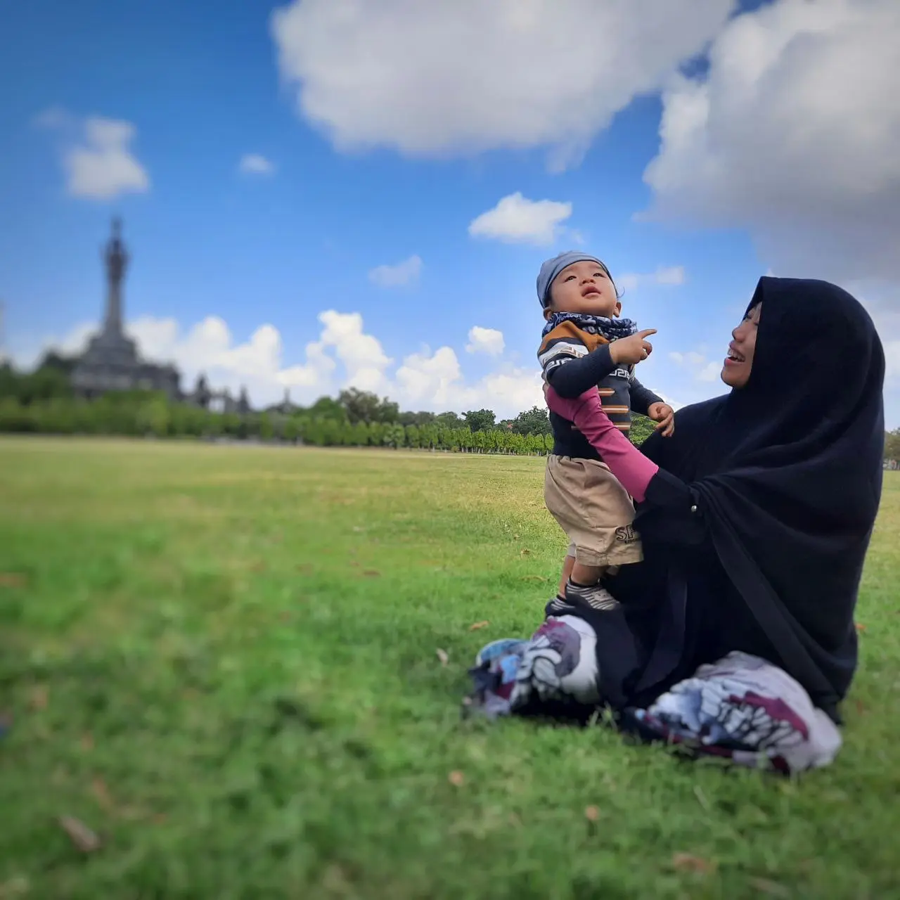 Ibu mendampingi anak memandang langit di ruang terbuka